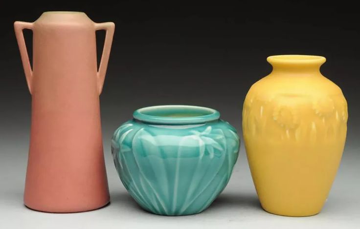 three different colored vases sitting next to each other