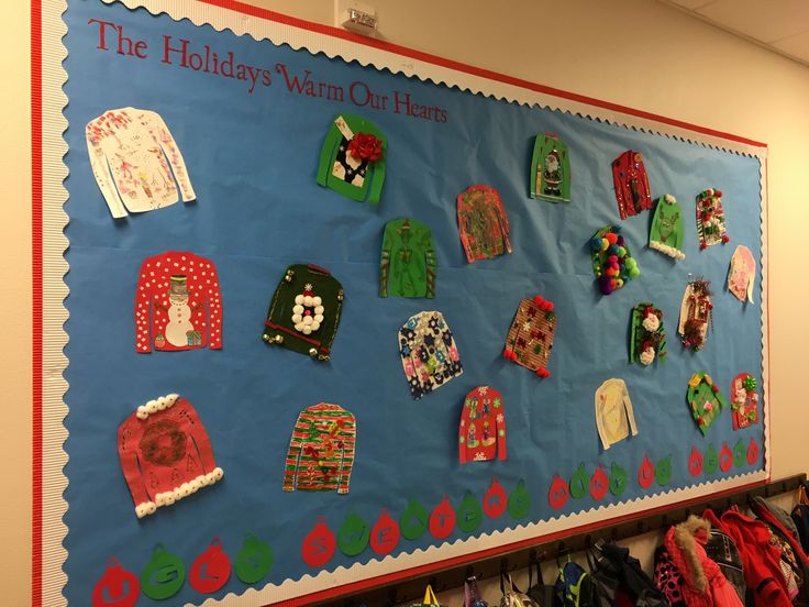 a bulletin board with ugly sweaters on it in a classroom or playroom area