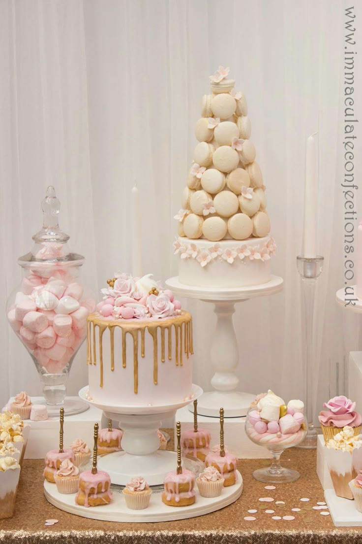 a table topped with lots of cakes and cupcakes