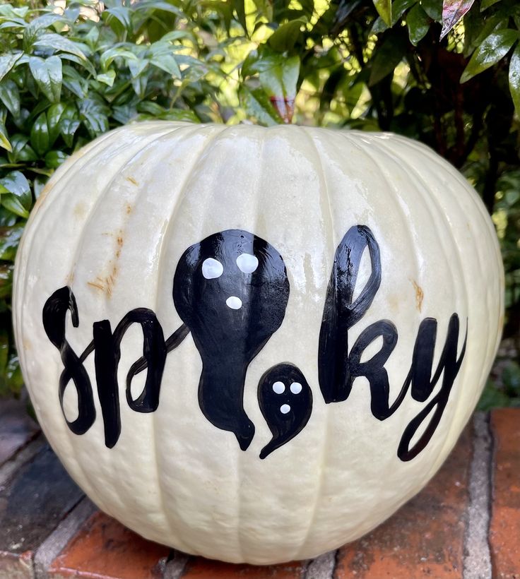 a white pumpkin with black lettering on it