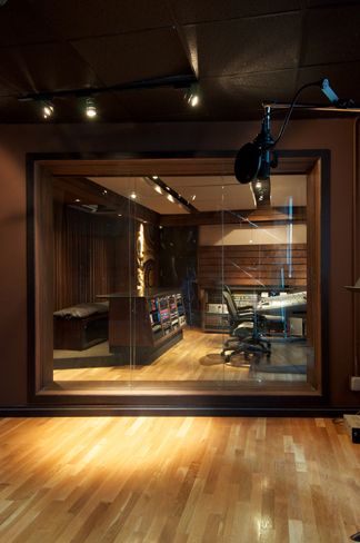 an empty room with hard wood floors and lights on the ceiling is lit by spotlights