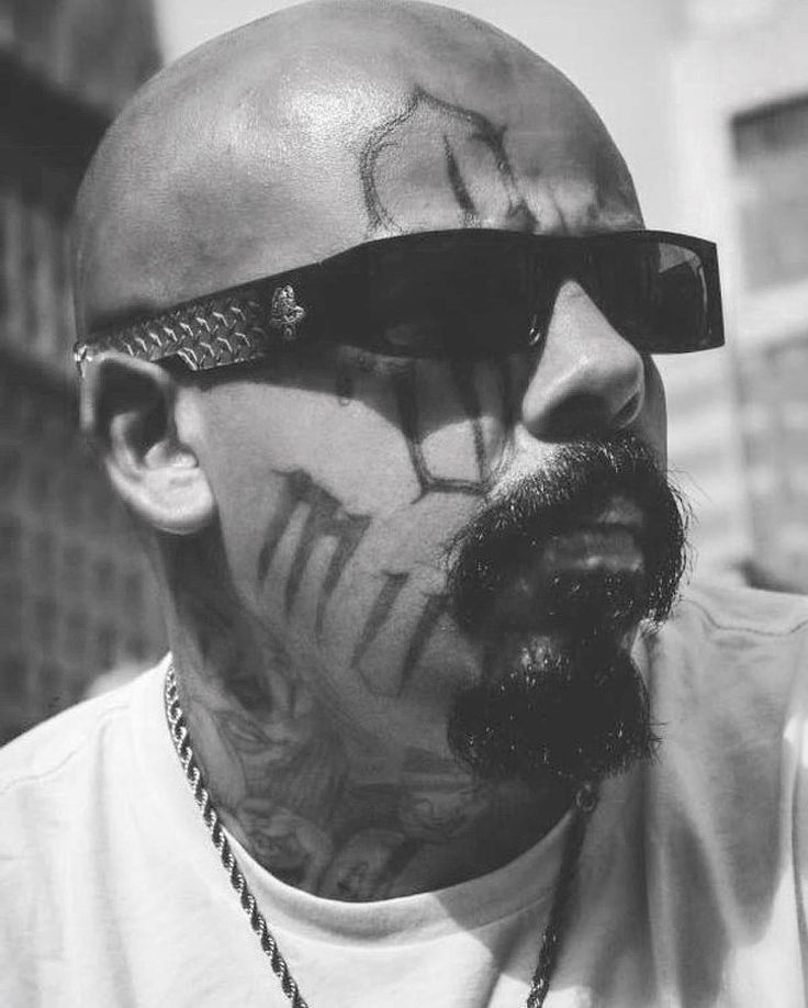 a man with tattoos on his face and sunglasses