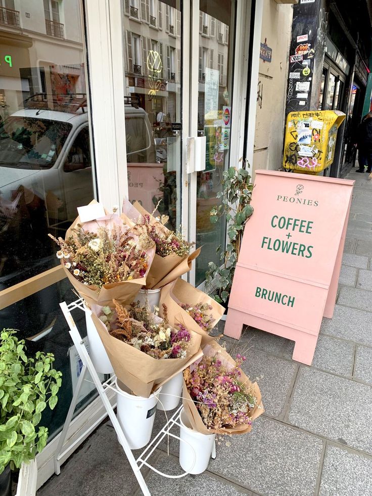 there are many flowers on display in front of the store