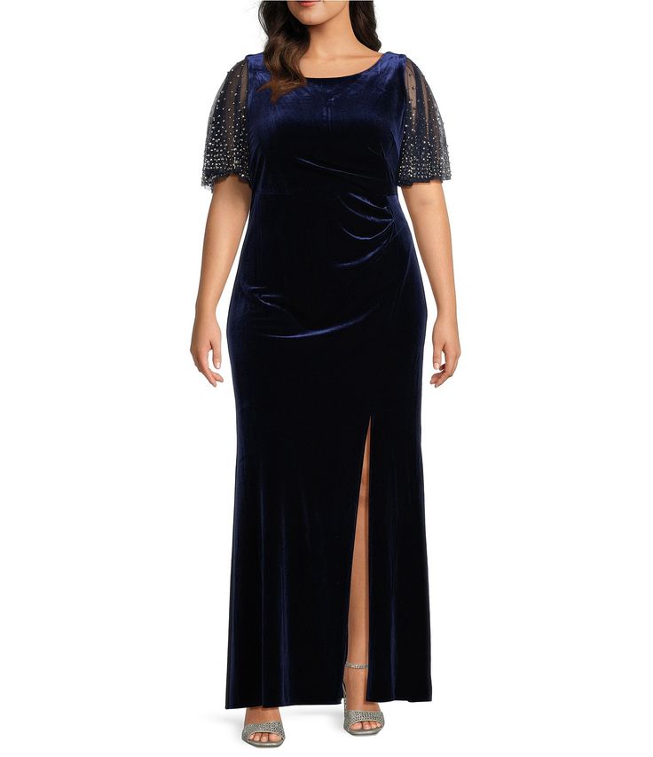 a woman wearing a blue velvet dress with sheer sleeves