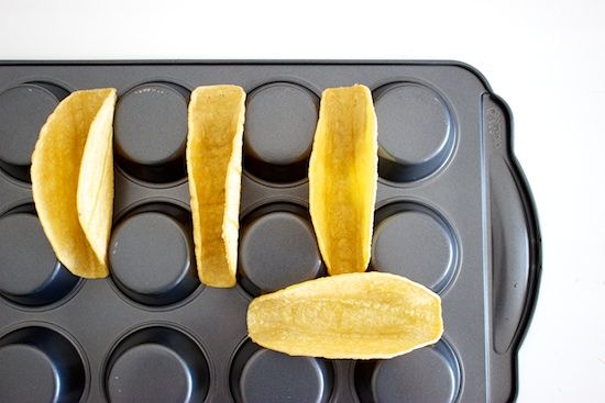 two peeled bananas sitting on top of a muffin tin