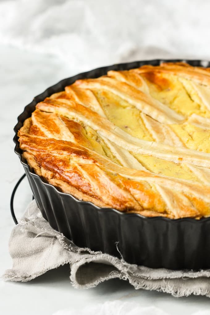 a pie sitting in a pan on top of a white tablecloth next to a fork