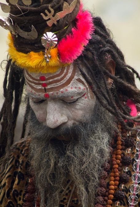 a close up of a person with dreadlocks wearing a costume and headdress