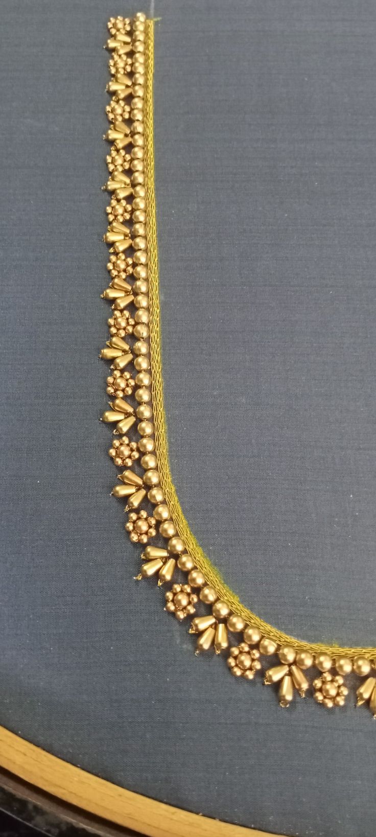 an elaborate gold necklace is displayed on a table