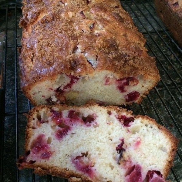 a loaf of fruit bread sitting on top of a metal rack next to an oven