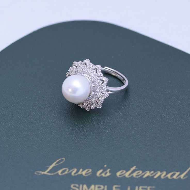 Get dressed up with our 10-11mm Freshwater Pearl & Round Cubic Zirconia. It has the perfect combination of elegance and style. The freshwater pearl creates a timeless look that makes this piece an ideal choice for any outfit. The round cut Cubic Zirconia add just the right amount of sparkle and shine to the overall design. This ring is perfect for special occasions or everyday wear, so you can show off your glamourous side no matter where you go. 10-11mm Freshwater Pearl Earrings This popular ea Brilliant Cut Pearl Ring, Fine Jewelry Pearl Ring With Cubic Zirconia, Elegant Pearl Ring With Diamond Center Stone, Luxury Round Pearl White Ring, Luxury Pearl White Round Pearl Ring, Elegant Open Pearl Ring, Elegant Brilliant Cut Pearl Ring, Round Cubic Zirconia Pearl Ring For Anniversary, Anniversary Pearl Ring With Cubic Zirconia