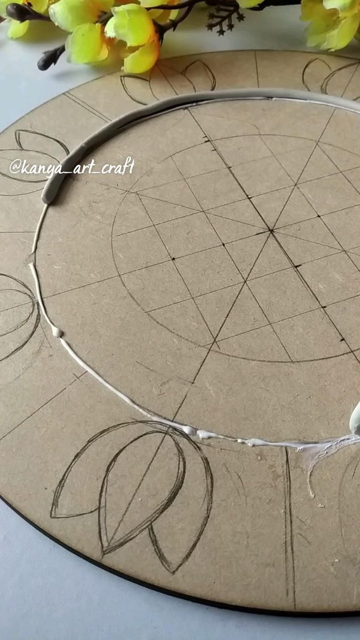 a circle with some wire on it next to flowers