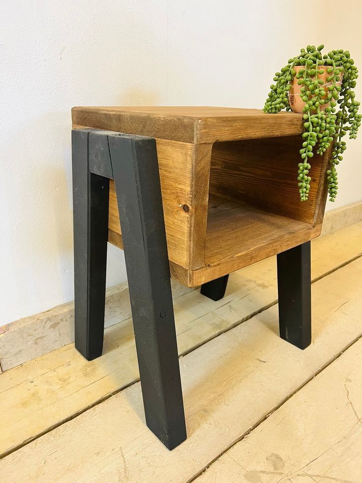 a wooden table with a potted plant sitting on it's legs and bottom shelf