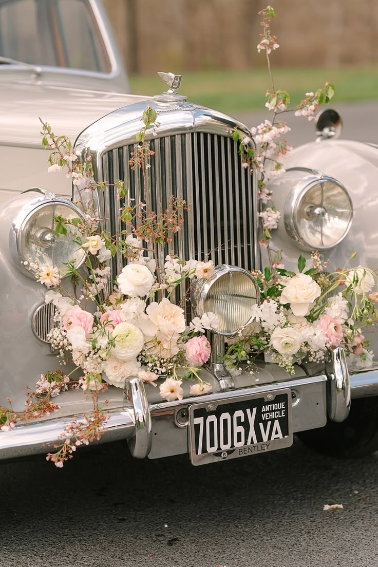 an old fashioned car with flowers on the front