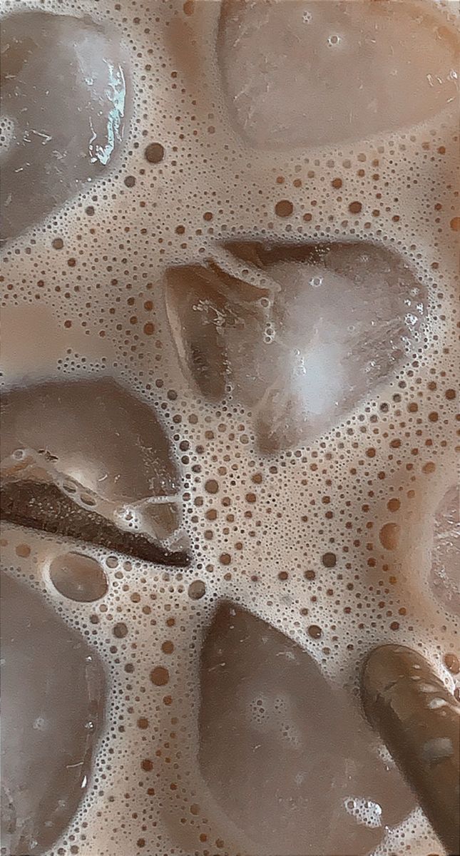 some ice cubes are sitting on top of the liquid in a glass bowl with water