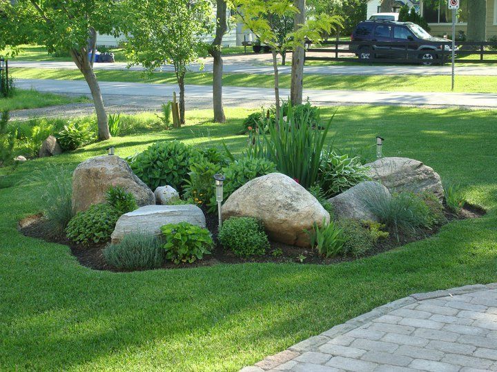 a rock garden in the middle of a lawn