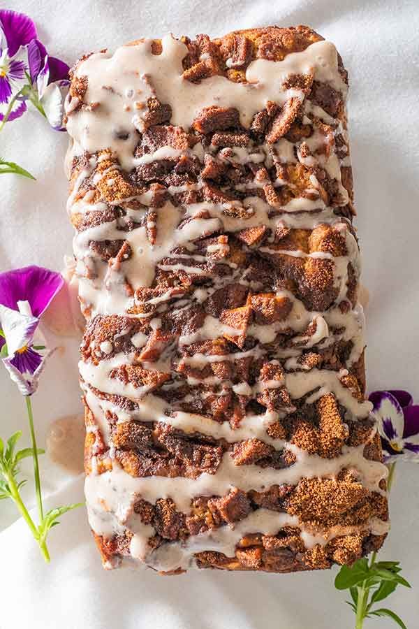 a loaf of cinnamon bread with icing and flowers