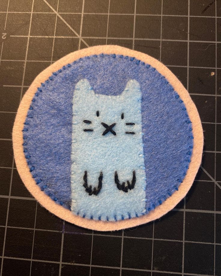 a blue and white patch with a cat on it's face in the center