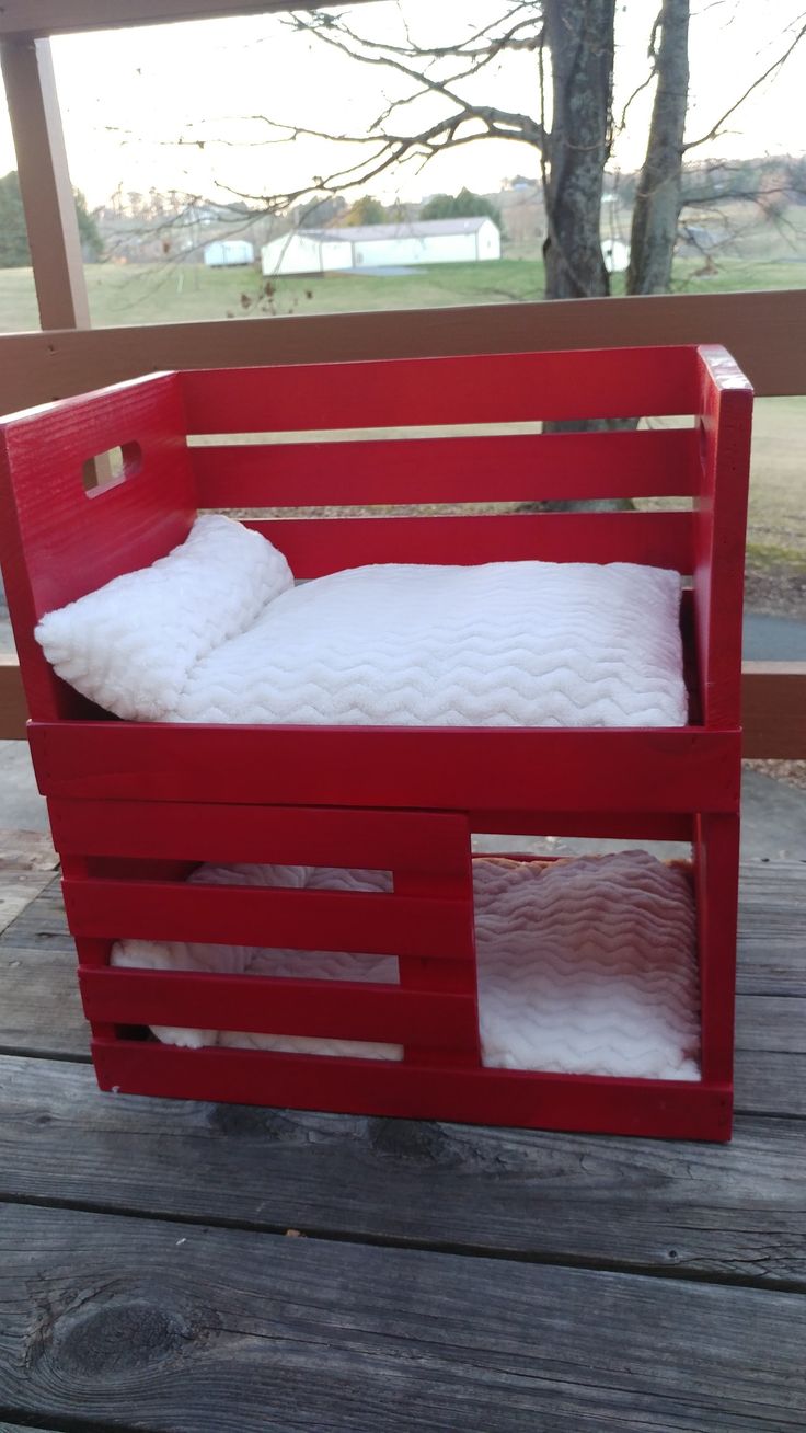 a bed made out of pallets on a wooden deck with trees in the background