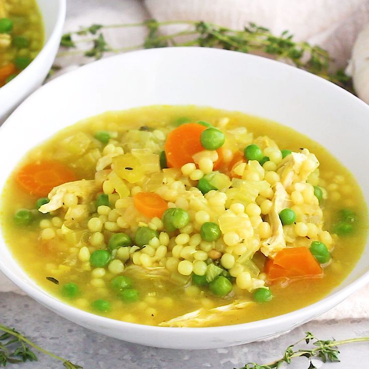 two white bowls filled with soup on top of a table