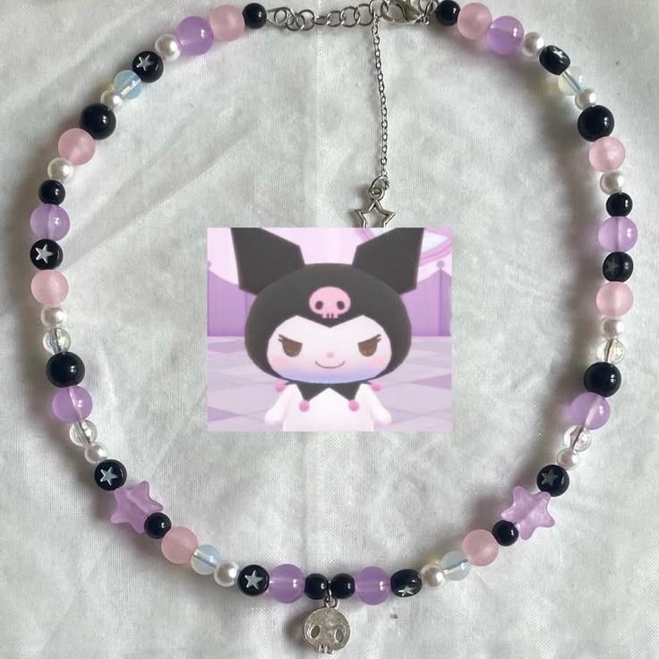 a necklace with an image of a cat on the front and purple beads around it