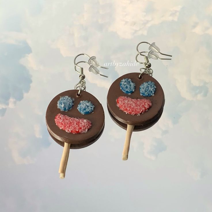 two popsicle shaped earrings with colorful sprinkles on them