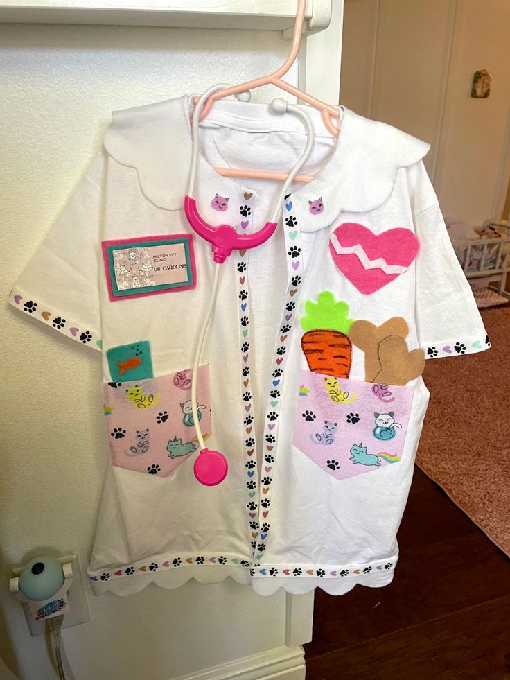 a child's shirt hanging on the wall in front of a door with a stethoscope attached to it