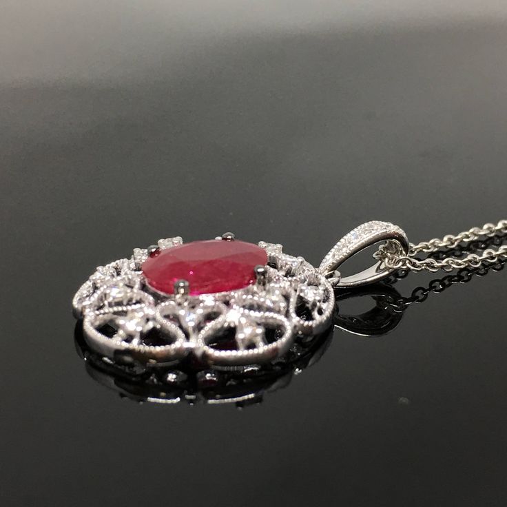 14K Ruby and Diamond Pendant METAL: 14K White Gold TOTAL WEIGHT: 1.7 g DIAMONDS: Round Brilliant Cut Diamonds COLOR: G/H CLARITY: VS2-SI1 TOTAL WEIGHT: 0.16 ct RUBY: Genuine Oval Cut Ruby MEASUREMENTS: 8mm x 6mm TOTAL WEIGHT: 1.40 ct Chain Length: 16, 18, or 20 inch chain is included with your purchase. Please indicate your desired length at checkout. DESCRIPTION: Beautiful Ruby and diamond pendant. This item has a lot of vintage flair. It looks gorgeous on. It's a little under an inch in length Luxury Ruby Necklace With Diamond Accents, Luxury Ruby Necklaces With Diamond Accents, Oval Diamond Filigree Necklace, Fine Jewelry Engraved For Evening Wear, Oval White Gold Necklace With Intricate Design, Exquisite Oval Necklace With Intricate Design, Formal Engraved Ruby Jewelry, Elegant White Gold Ruby Necklace, Oval Diamond Necklace With Intricate Design