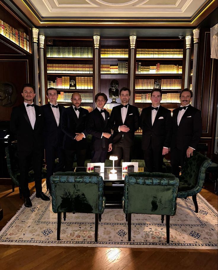 a group of men in tuxedos standing next to each other on a rug