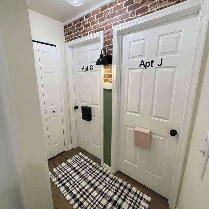 two white doors with black and white checkered rug on the floor next to them