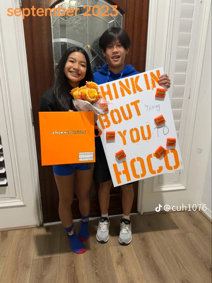 two people holding up signs in front of a door