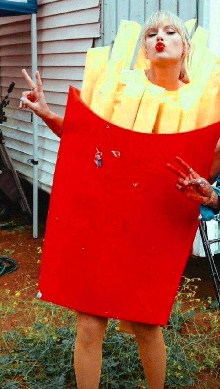 a woman is dressed up as a box with fries in it and holding her hands out to the side