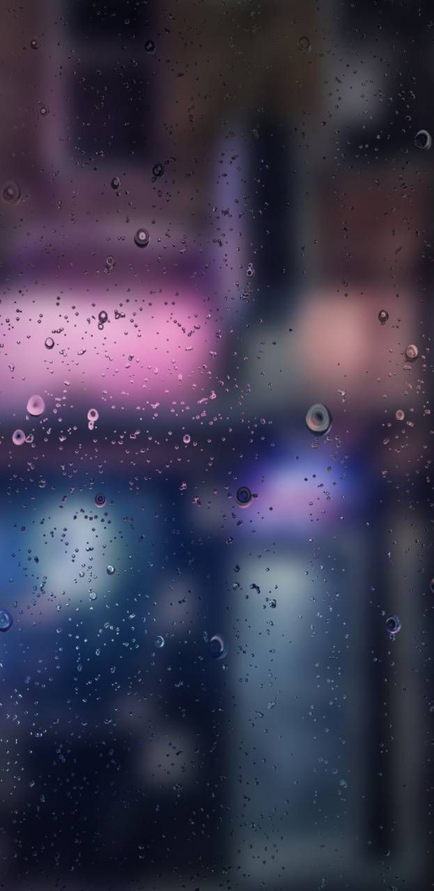 rain drops on the window with blurry background and pink car in backgroud