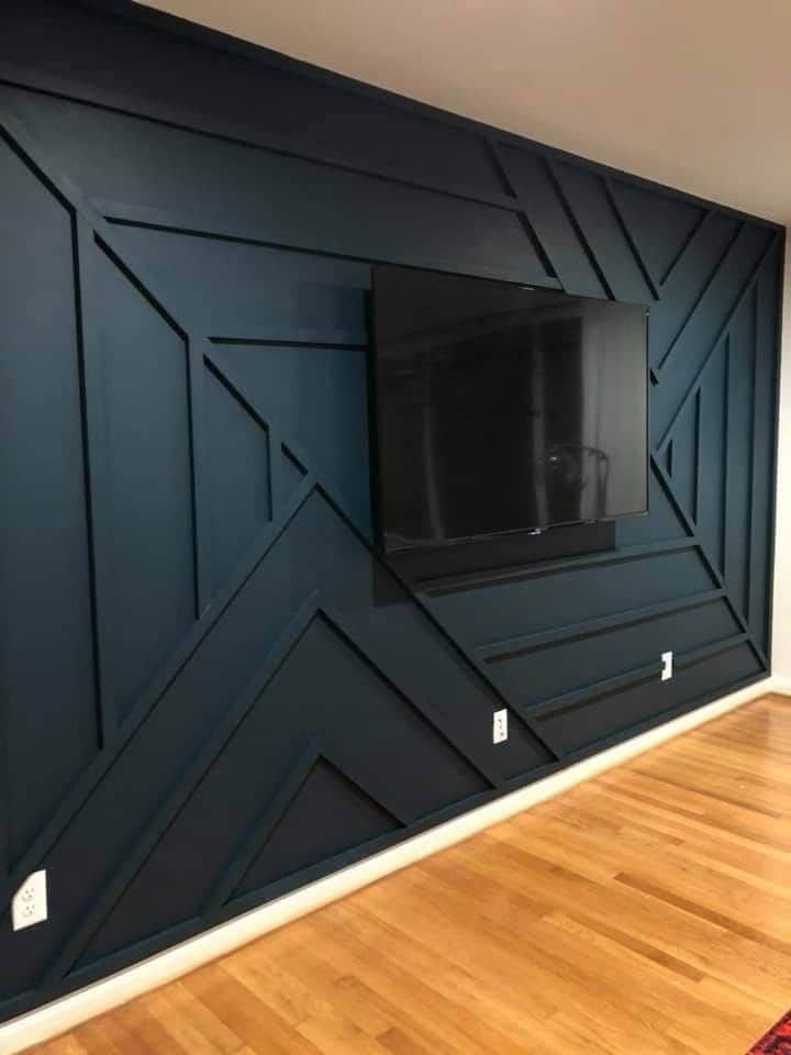 a flat screen tv mounted to the side of a wall in a room with wood floors