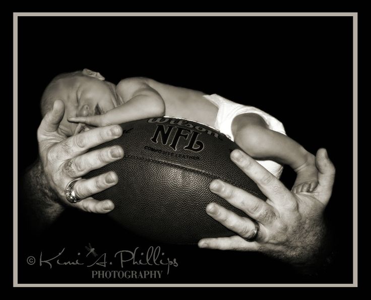 a black and white photo of a man holding a football with his hands on the ball