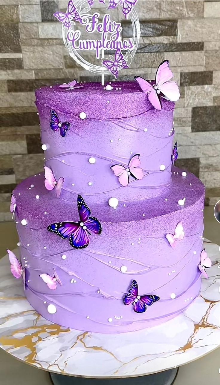 a three tiered cake with purple frosting and butterflies on it's side