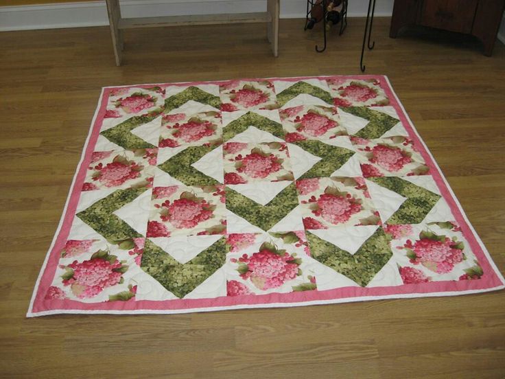 a pink and green quilt on the floor