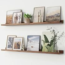 two wooden shelves with pictures and plants on them