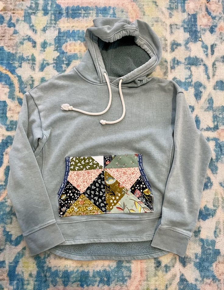 a gray hoodie with patchwork pocket on it