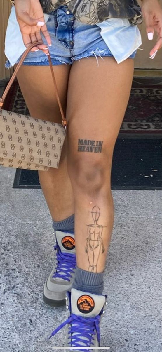 a woman with tattoos on her legs holding a purse