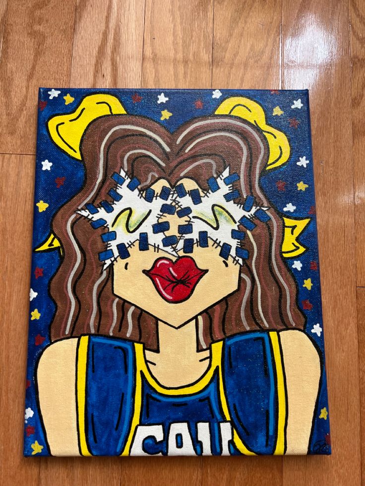 a painting of a woman's face on a wood floor with blue and yellow stars