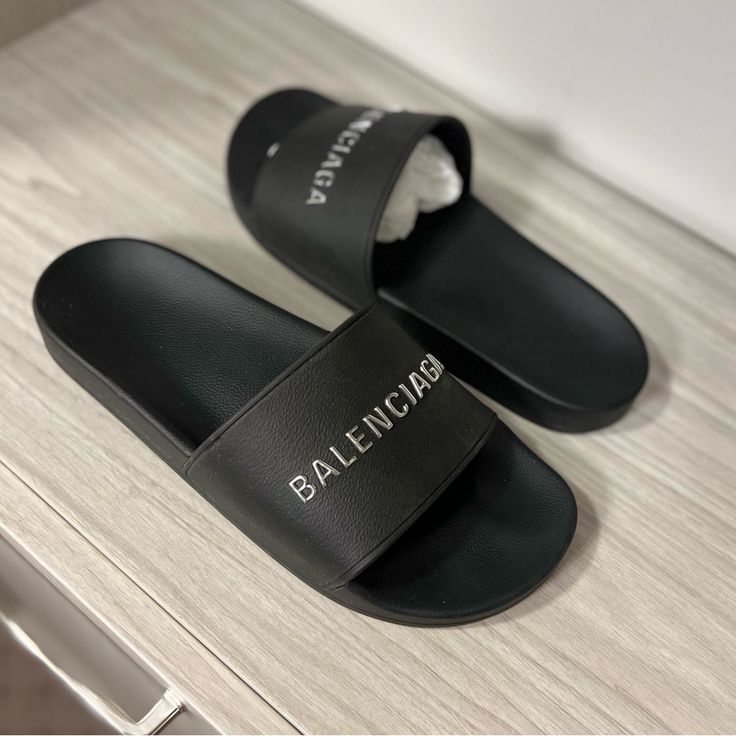 Black Balenciaga Pool Slides In Excellent Used Condition. Only Worn To The Pool 2 Times Where They Were Taken Off Majority Of The Time. Size 12 But I Am A True Size 10 And They Fit Perfectly. Rubber Slide Sandal Molded Rubber Footbeds Silver Chrome Balenciaga Logo On The Strap Tone-On-Tone Sole And Insole Made In Italy Wipe With A Soft Cloth Material: 100% Tpu Shoes Balenciaga, Black Balenciaga, Pool Slide, Balenciaga Logo, Balenciaga Black, Silver Chrome, Cloth Material, Pool Slides, The Pool