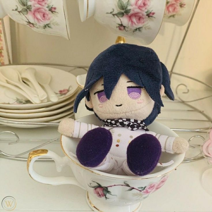 a stuffed doll sitting in a teacup