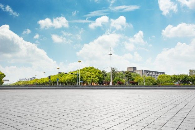 an empty parking lot surrounded by trees and buildings