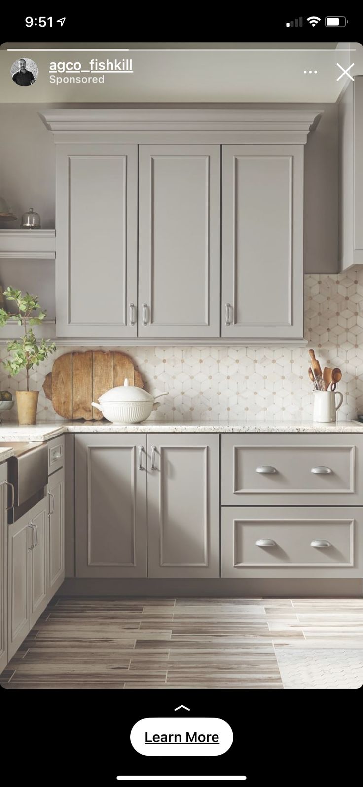 an image of a kitchen with white cabinets and wood flooring on the phone screen