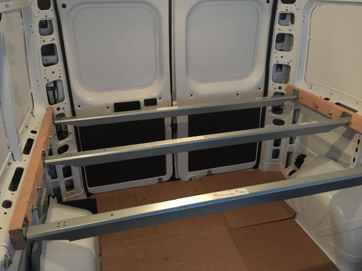 the inside of a van with two doors and some shelves on each side for storage