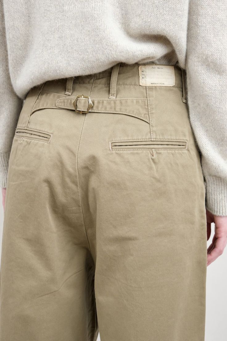 The Chino High Waist NIME Pants are a slightly oversized barrel leg pant with front pleats. Featuring the signature Kapital posterior waist buckle, these pants are a take on a classic trouser with a touch of modern style. Fasteners Clothing, Khaki Color Combination, Chinos Women Outfit, Bush Pants, Menswear Pants, Sunday Market, Beige Chinos, Trousers Details, Womens Chinos