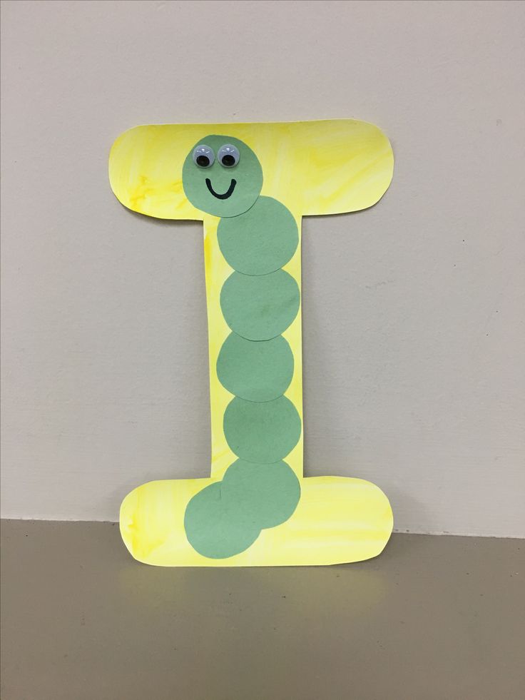 the letter i is made out of paper with a smiling caterpillar on it