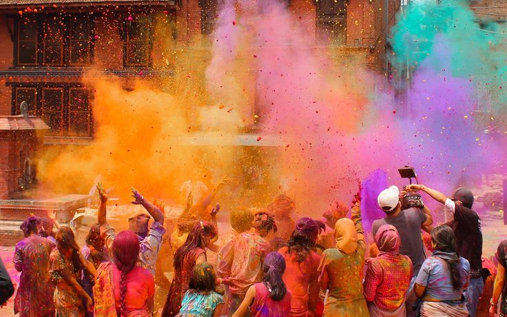 people are throwing colored powder on each other