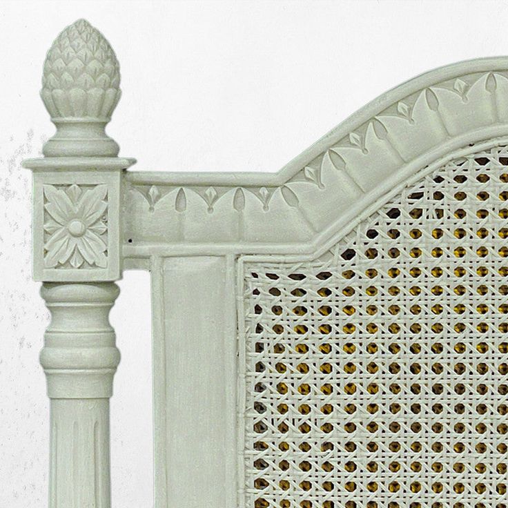 a white bed frame with intricate carvings on it