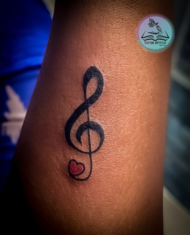 a tattoo with a musical note on it's side and a heart in the middle